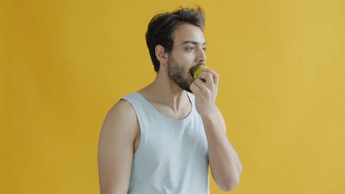 Young Man Eating Green Apple for Healthy Lifestyle