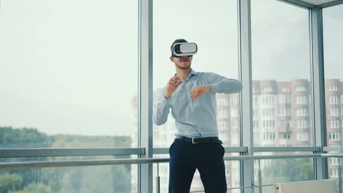 Close Up Young Man Sitting at a Desk in the Office Uses Augmented Reality Glasses To Work on