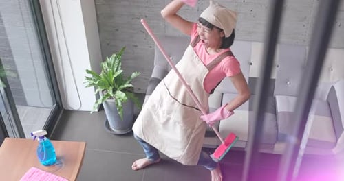Woman Singing and Dancing with Mop Indoors