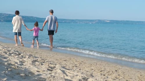 Parent with child walk by the sea.