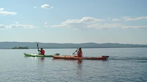 Kayakers Paddle Across a Calm Mountain Lake