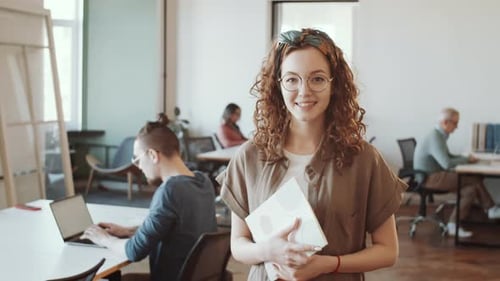 Portrait of Young Cheerful Woman at Work in Open Space Office