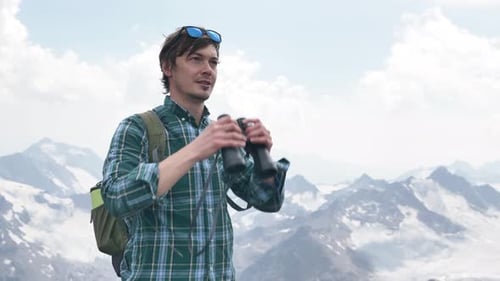 Man Hikes Mountain and Looks at View