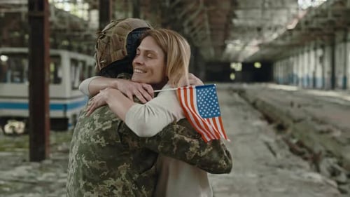 Back View of American Soldier Hugging Wife on Plant