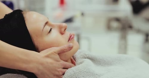 Woman Receiving Relaxing Facial Massage in Beauty Clinic