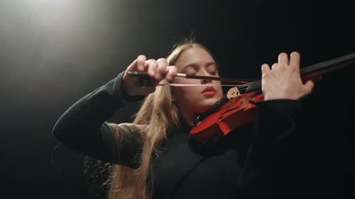 Female Violinist is Playing Modern Classic Music in Dark Philharmonic Hall Portrait