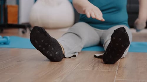 Close Up of Elder Adult Stretching Arms and Legs on Yoga Mat