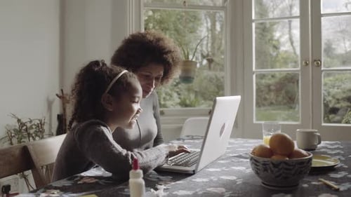Mother and Daughter Using Laptop Computer at Home