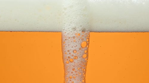 Close up background of beer with bubbles in glass
