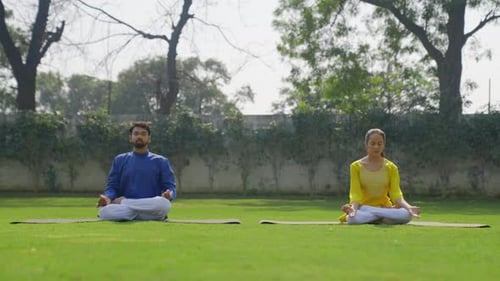Couple Meditating Outdoors in Green Garden Setting