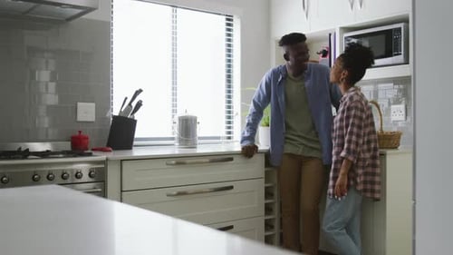Young Couple Talking and Embracing in Kitchen