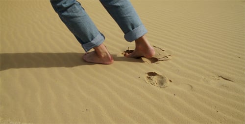 Bare Feet Walking Across Sand Dunes
