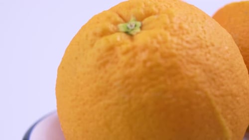 Nahaufnahme von frischer Valencia-Orange, geschnitten mit weißem Hintergrund, flachem Fokus und langsam rotierend.