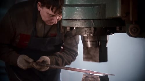 Blacksmith Workshop a Man Shaping Heated Metal Using Automatic Pressing Machine
