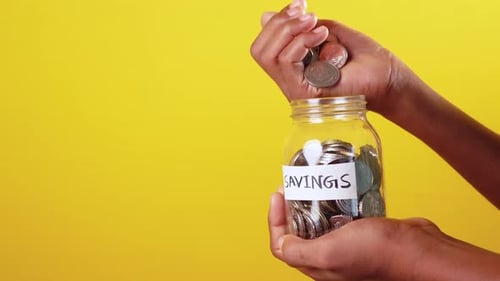 Saving Money Coins Dropped into Jar