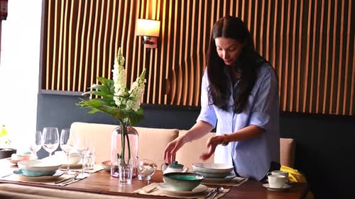 Woman Sets Elegant Dining Table at Home