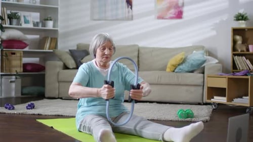 Senior Woman Exercising with Resistance Ring at Home