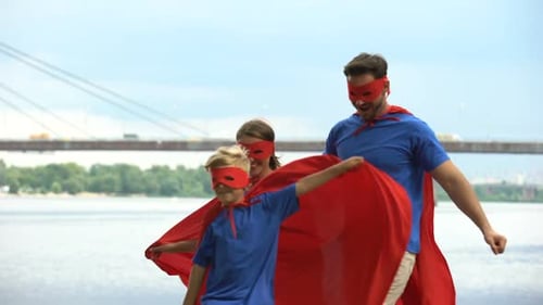 Family dressed as superheroes by river