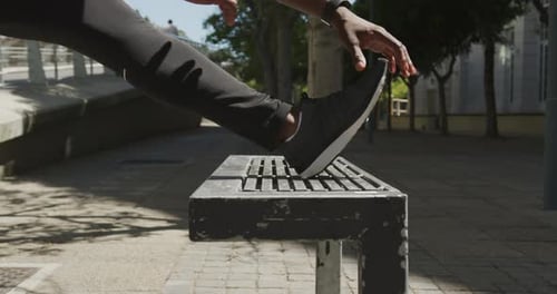 Adult Stretching Leg on Bench on Sunny Day