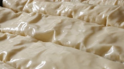 Spreading fat and egg rolled thin sheets of dough with filling 4K 2160p 30fps UHD footage - Oiling