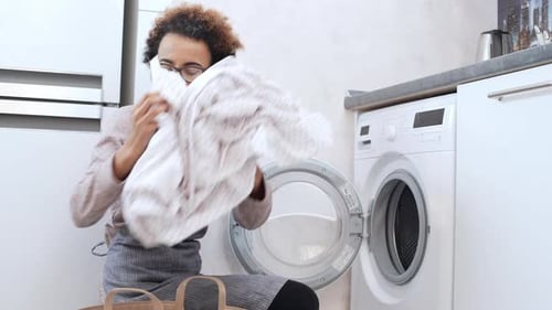 Woman Taking Laundry out of Washing Machine