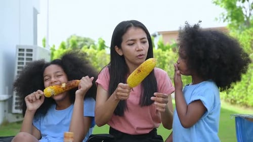 Woman and Children Eating Corn on the Cob