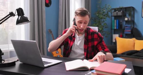 Young Adult Talking on Phone, Working at Desk
