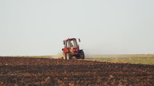 Red Tractor Working in Agricultural Field