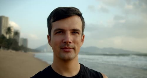 Young Handsome Caucasian Man Looking at the Camera Smiling Against the Backdrop of the Beautiful Sea