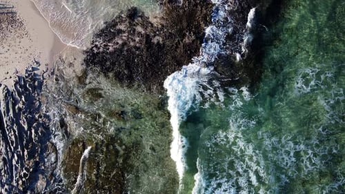 Pequenas ondas espumosas, vista ondulante de um drone em azul turquesa, oceano quebrando ondas e cal