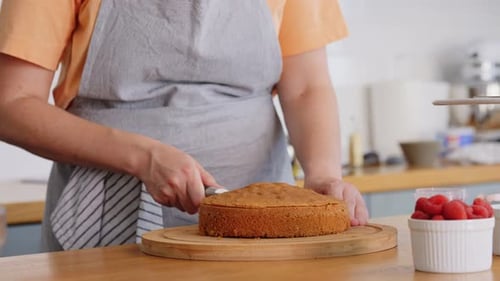 Woman Slicing Cake in Kitchen for Baking Project