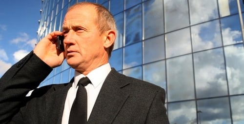 Empresário falando no telefone do lado de fora