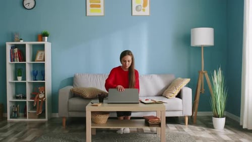 Woman Opens Laptop on Couch at Home
