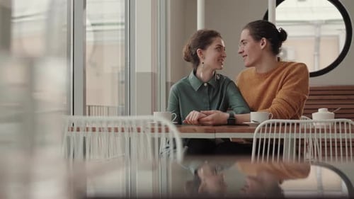 Two Young People Having Pleasant Conversation in Cafe