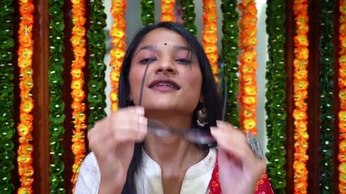 Smiling Woman Removes Glasses in Front of Garland