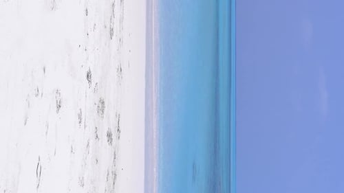 Man in Santa Hat Dancing on Sandy Beach