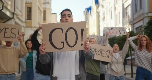 Public Demonstration at City Street with Hispanic Man in Front of Multiracial Protesting People