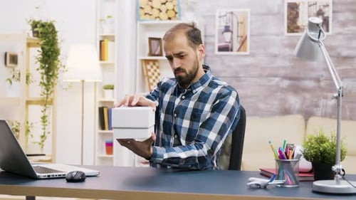 Man Unboxes New Smartphone at Desk
