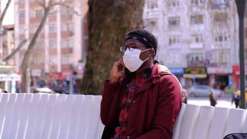 Schwarzer junger Mann Maske Telefon