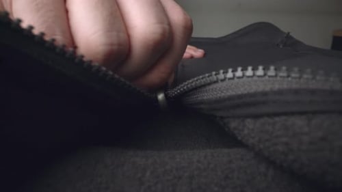 Extreme Close Up Zipper with Hand Unzipping the Sweater Jacket Zipper