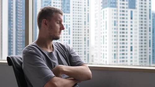 Hombre de oficina cansado y sobrecargado de trabajo mirando por la ventana