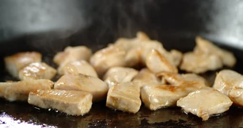 Pieces of Meat Cooking on a Pan