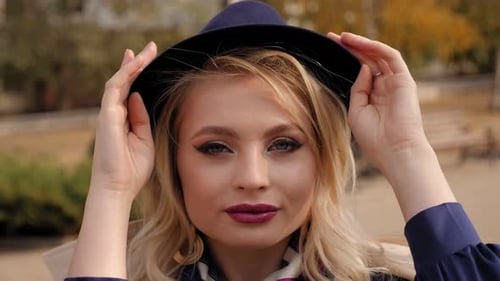 Portrait of Young Beautiful Woman in a Coat and Black Hat in an Autumn City Park