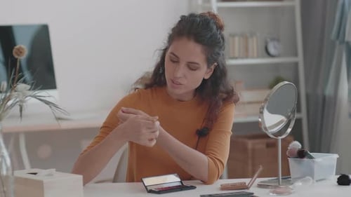 Chica usando la paleta de sombras de ojos en la cámara