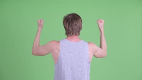 Rear View of Happy Young Man with Fists Raised