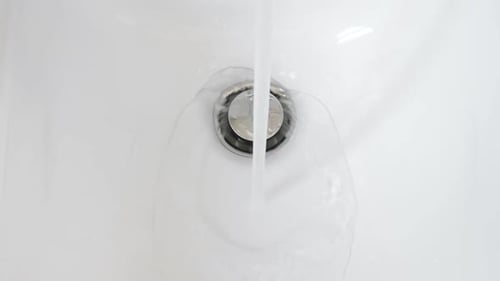 A água está correndo para o bidê de cerâmica