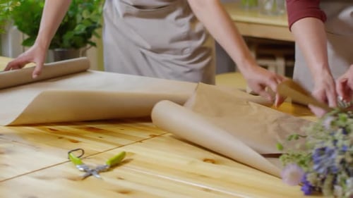Florists Collaborating to Wrap a Flower Bouquet