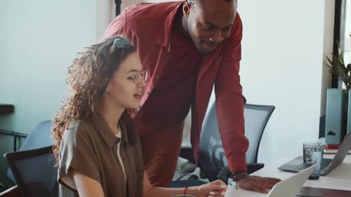 Colleagues Working Together at a Laptop in Office