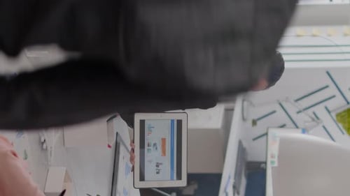Woman Presenting Data on Tablet in Office