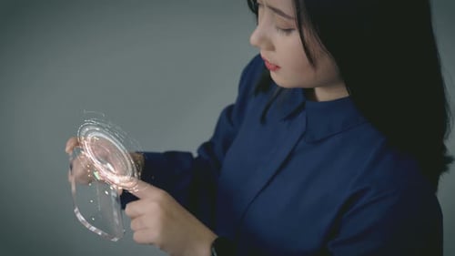 Woman Interacting with Holographic Interface on Transparent Device